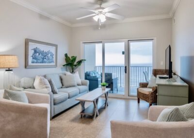 Living room of condo with contemporary furnishings with beautiful view of the Gulf waters out the glass doors.